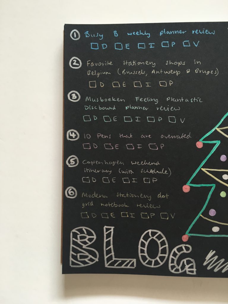 christmas themed bullet journal weekly spread black paper with metallic pens